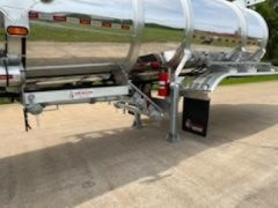 Trailer underside and frame of a new 2026 Dragon 8400 crude oil trailer with polished metal tank and support legs.