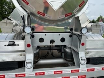 Front view of a new Crude Oil Trailer (Dragon 8400) rear section with twin landing gear and polished metal components; visible hoses, frames, and mounting brackets.