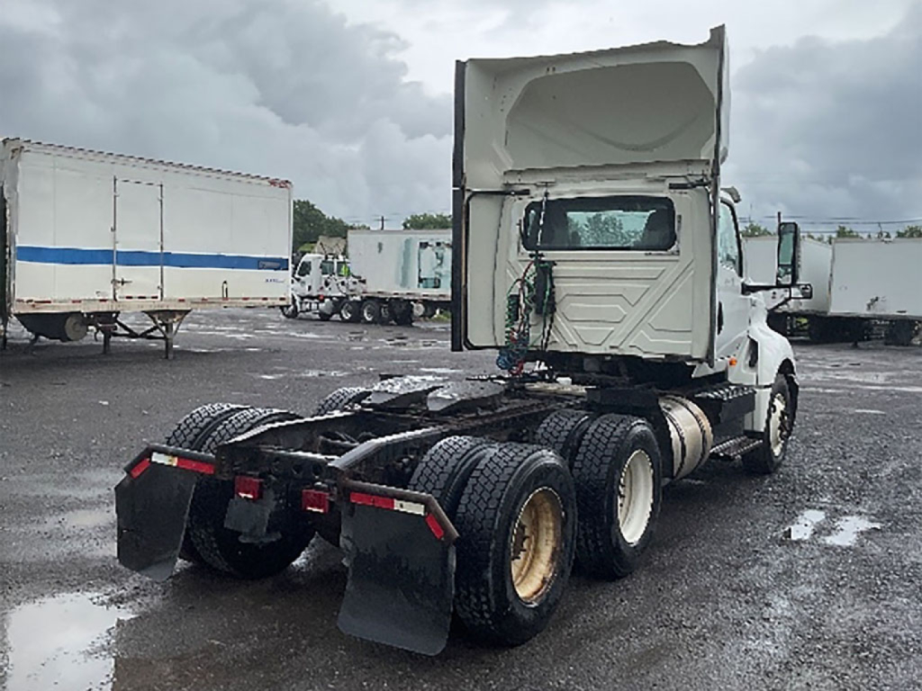 Truck chassis and cab of a 2019 International LT625 used conventional daycab showing rear dual-wheel assembly and fifth wheel area.