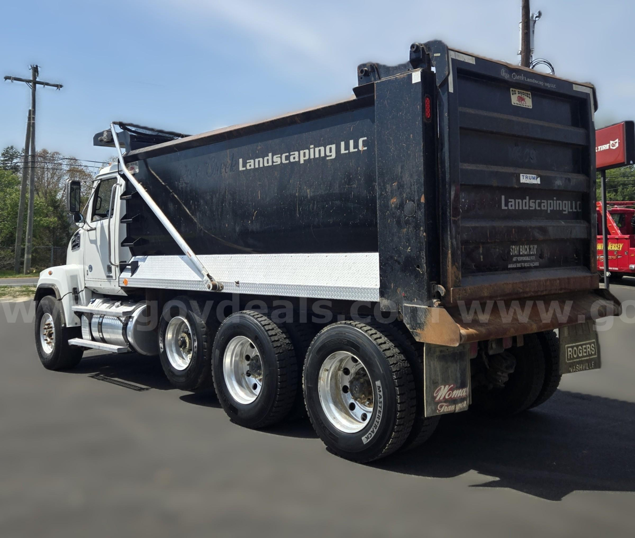Dump truck rear and side view showing Lands caping LLC dump bed and Western Star chassis.