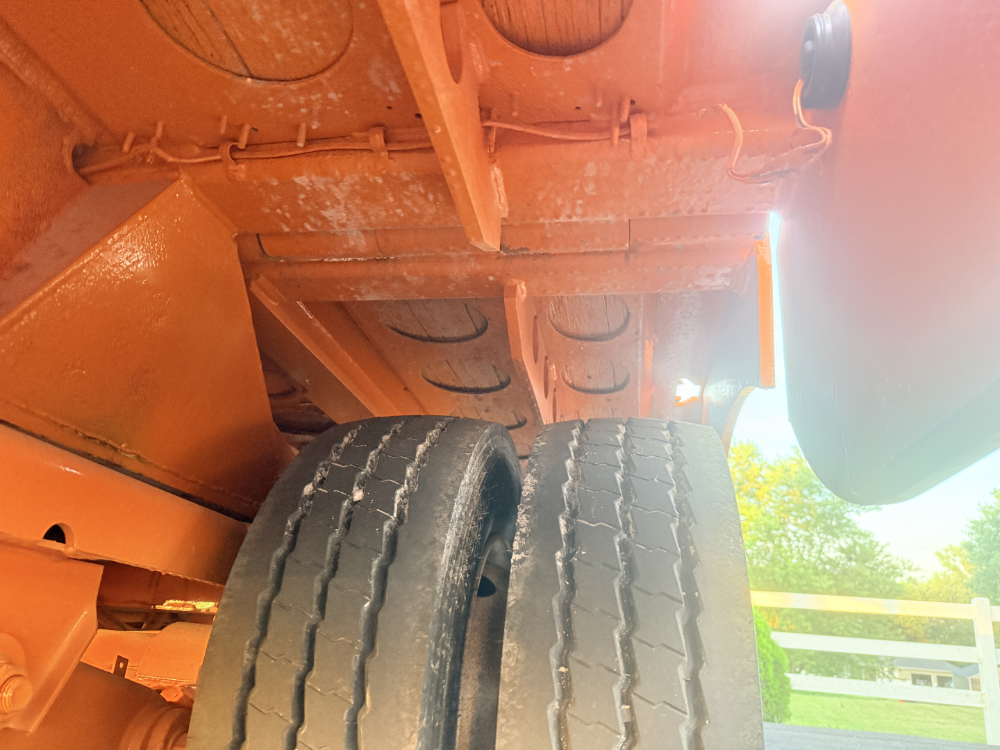 Underbody view of a Landoll trailer showing dual wheels and undercarriage components. Visible text includes VIN-like numbers and structural elements but no legible labels or fluids.