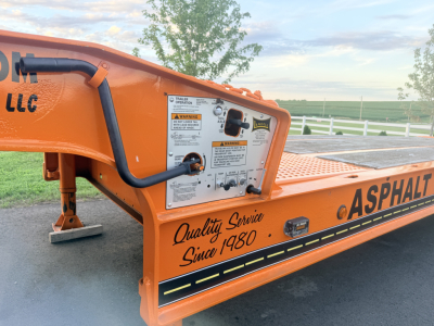 Traveling tail of a 2006 Landoll 930-51-15 lowboy trailer showing label plate and warnings on orange frame with black graphics and "Quality Service Since 1980" script.