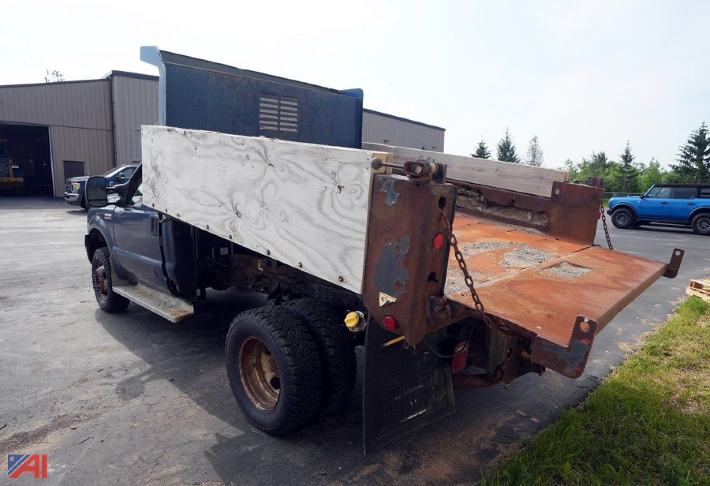 Ford F-350 XL SD dump truck rear view showing dump bed and hoist mechanism.