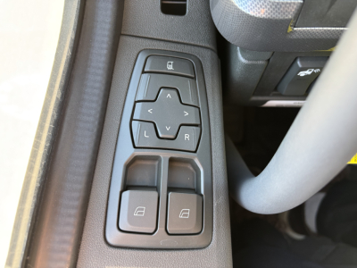Door control panel in a Volvo truck interior with window lock and mirror adjustment buttons visible.