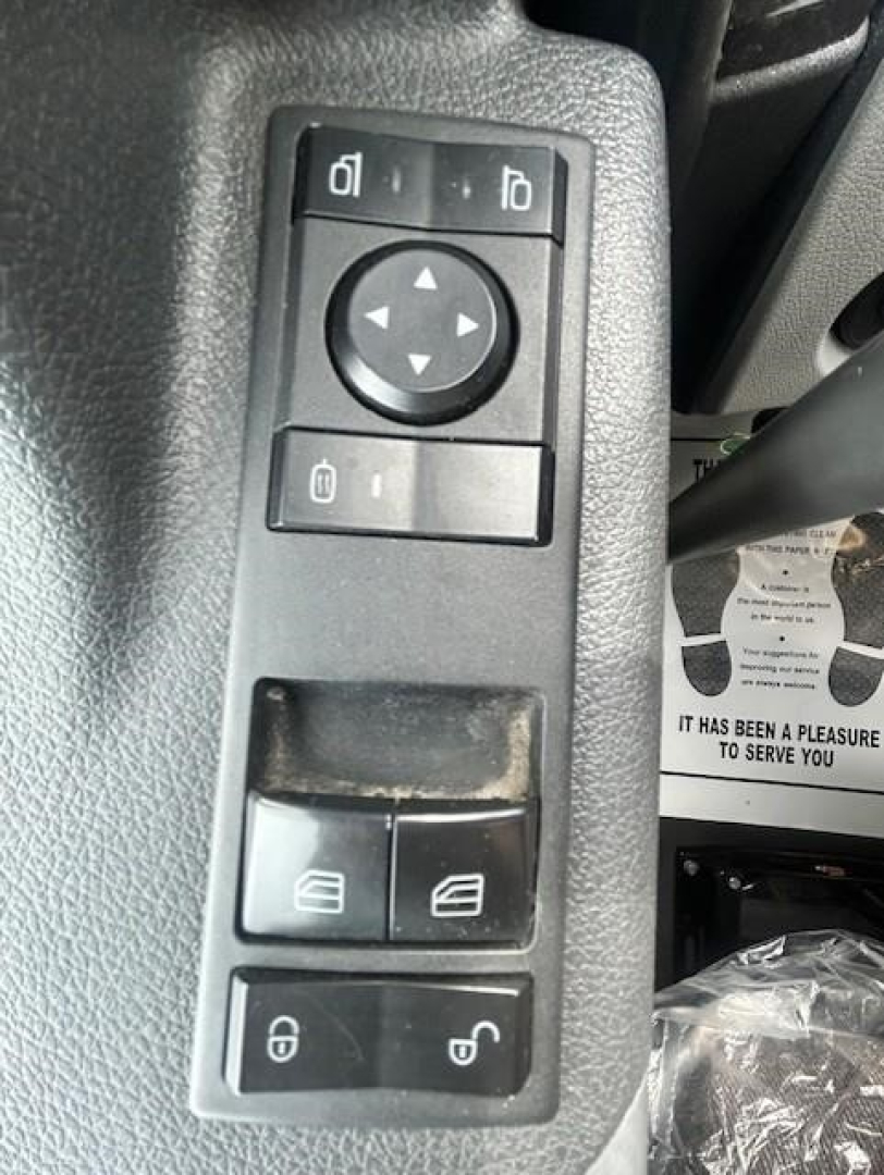 Freightliner Cascadia 126 interior door/control panel showing mirror ajust, window, and lock switches.
