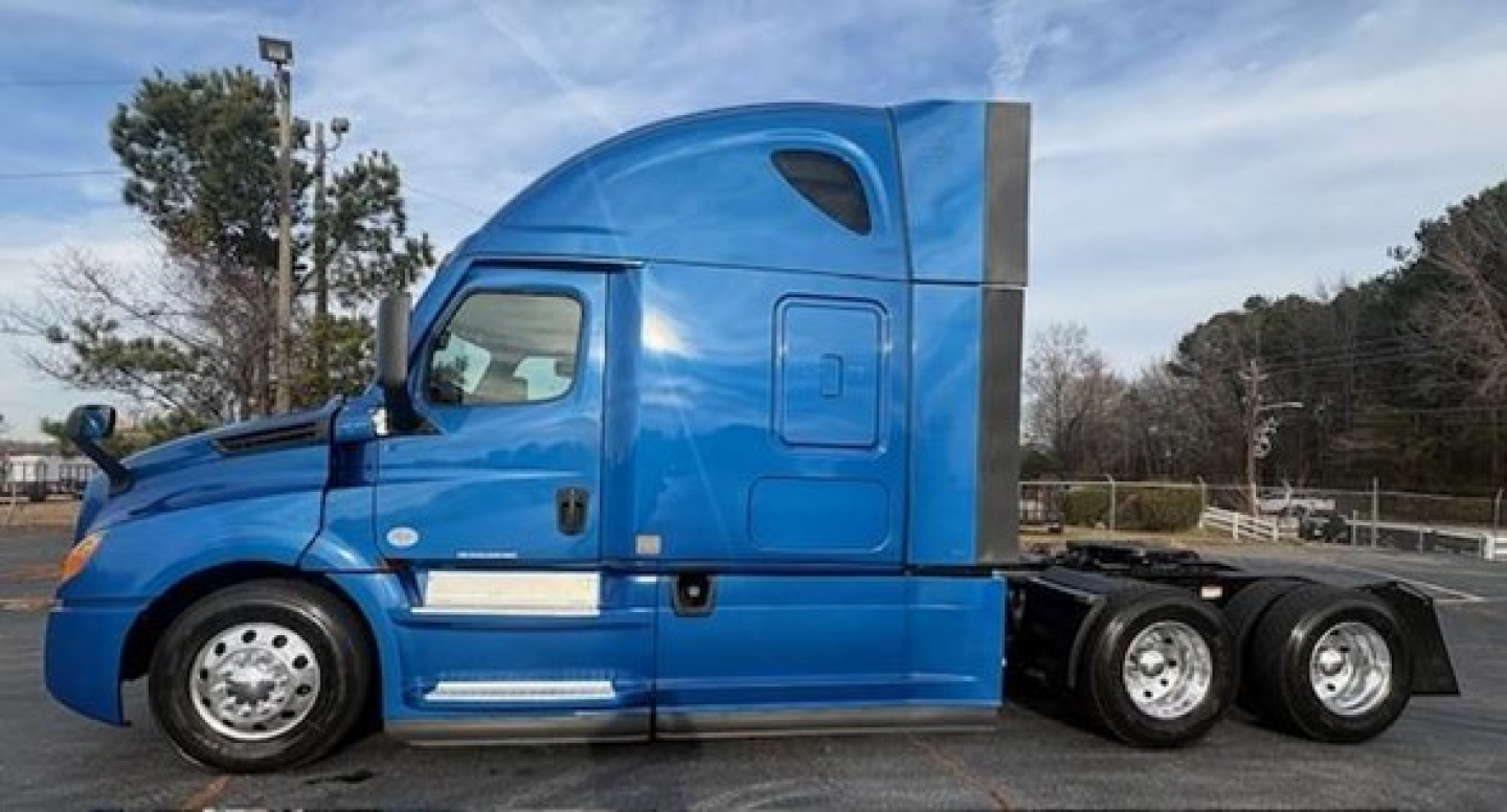 Freightliner Cascadia 126 sleeper cab side profile showing blue tractor with dual rear axles and chrome accents.