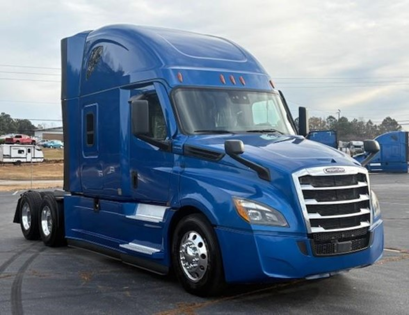  Freightliner Cascadia 126 tractor in blue, front three-quarter view with sleeper cab, chrome grille, large side mirrors, highway tires.