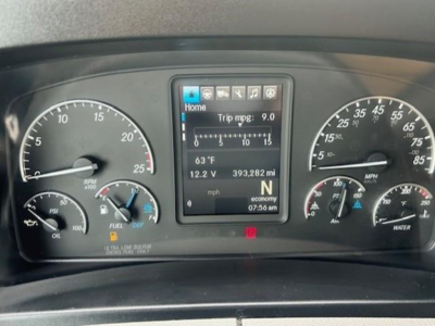 Dashboard of a 2022 Freightliner Cascadia 126 showing instrument cluster with speedometer, tachometer, and a central digital display reading Home, trip mpg 9.0, 63°F, 12.2 V, 393,282 mi.