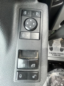 Freightliner Cascadia 126 interior door/control panel showing mirror ajust, window, and lock switches.