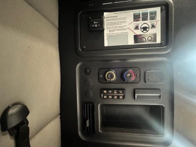 Freightliner Cascadia dashboard panel with control knobs and storage opening visible.