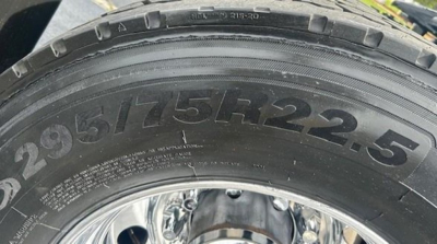 Tire sidewall showing size 295/75R22.5 and wheel rim visible.