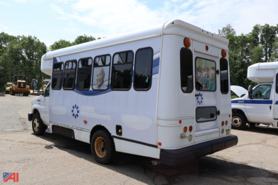 Ford E-350 wheelchair bus rear three-quarter view with white body and blue stripe accents.