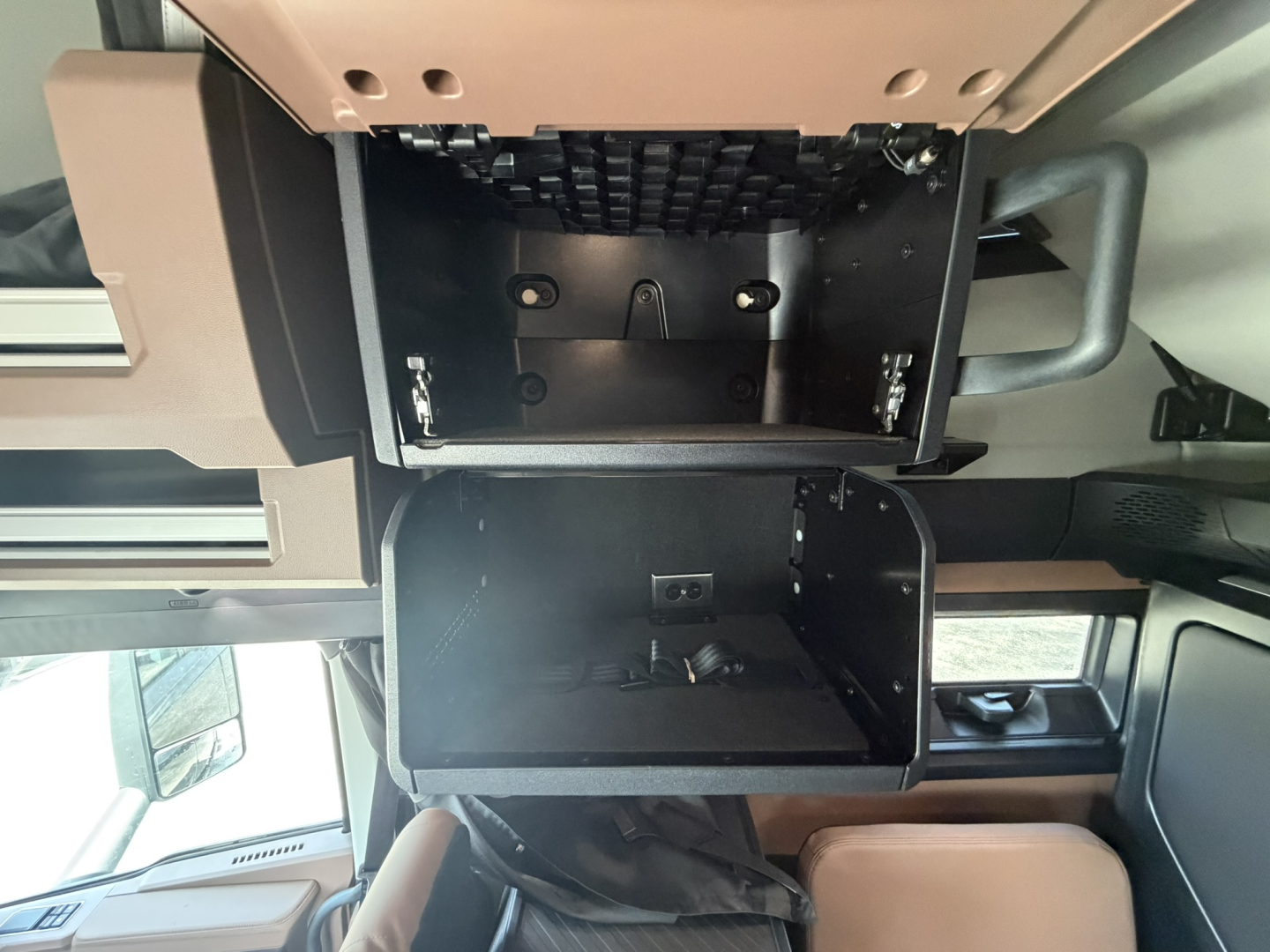 Cab interior of a Mack PR64T76H truck showing a storage compartment and dash area.