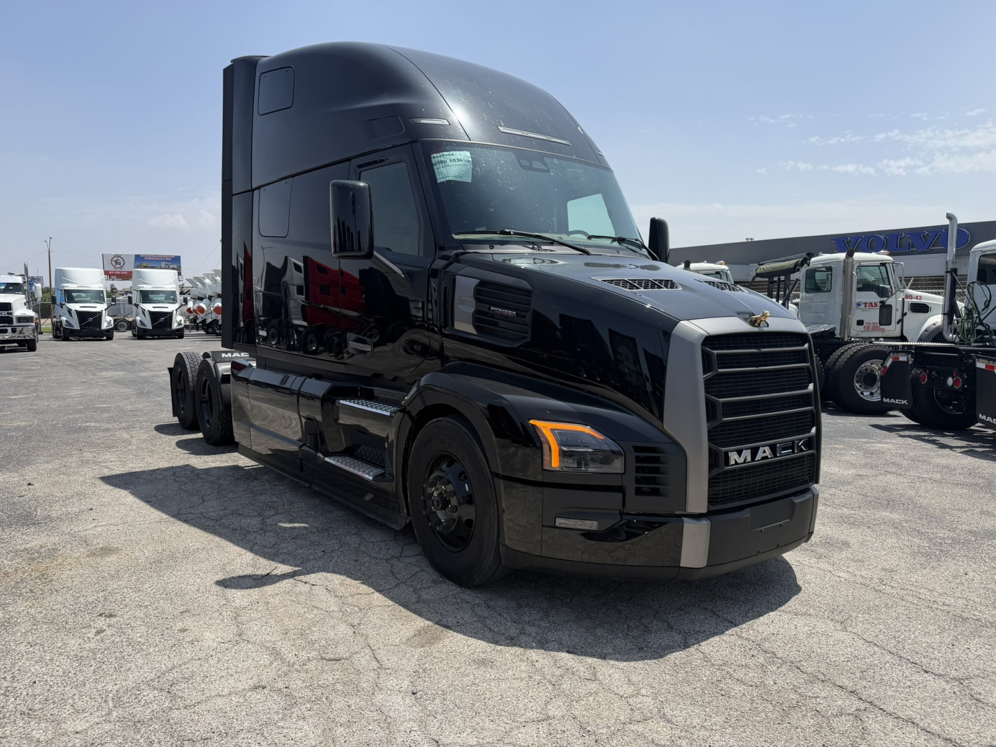Truck cab with MAC behind grille, front-left view. Visible text includes MAC on grille, Mack logo on hood, and small decals on windshield. No other legible labels or numbers visible.