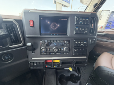 CAB dashboard of a 2027 Mack PR64T76H showing digital gauge display, climate controls, switches, and cup holders.