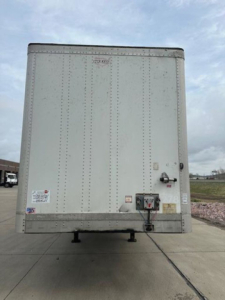 Rear view of a 2014 Wabash van trailer with riveted aluminum panels, rear door with latch and electrical connection. VIN tag not legible.