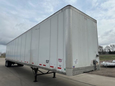 Trailer side view showing a white 53' Wabash van trailer with riveted aluminum panels, rear and front corners, wheel area, and support legs.
