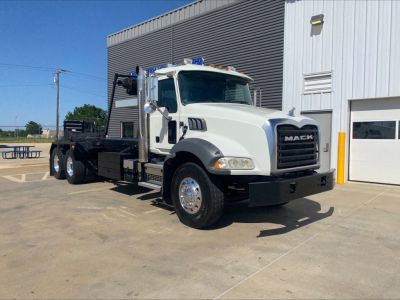Mack GU533 rolloff truck shown in side/front angle with white cab and black chassis, VIN 1M2AX33C1GM010946, stock B3199P.