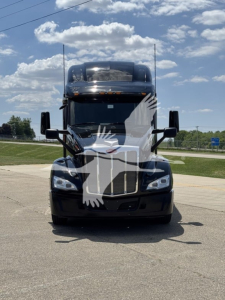 Peterbilt 579 front view truck showing large black grille, dual tall exhaust stacks, and aerodynamic mirrors.