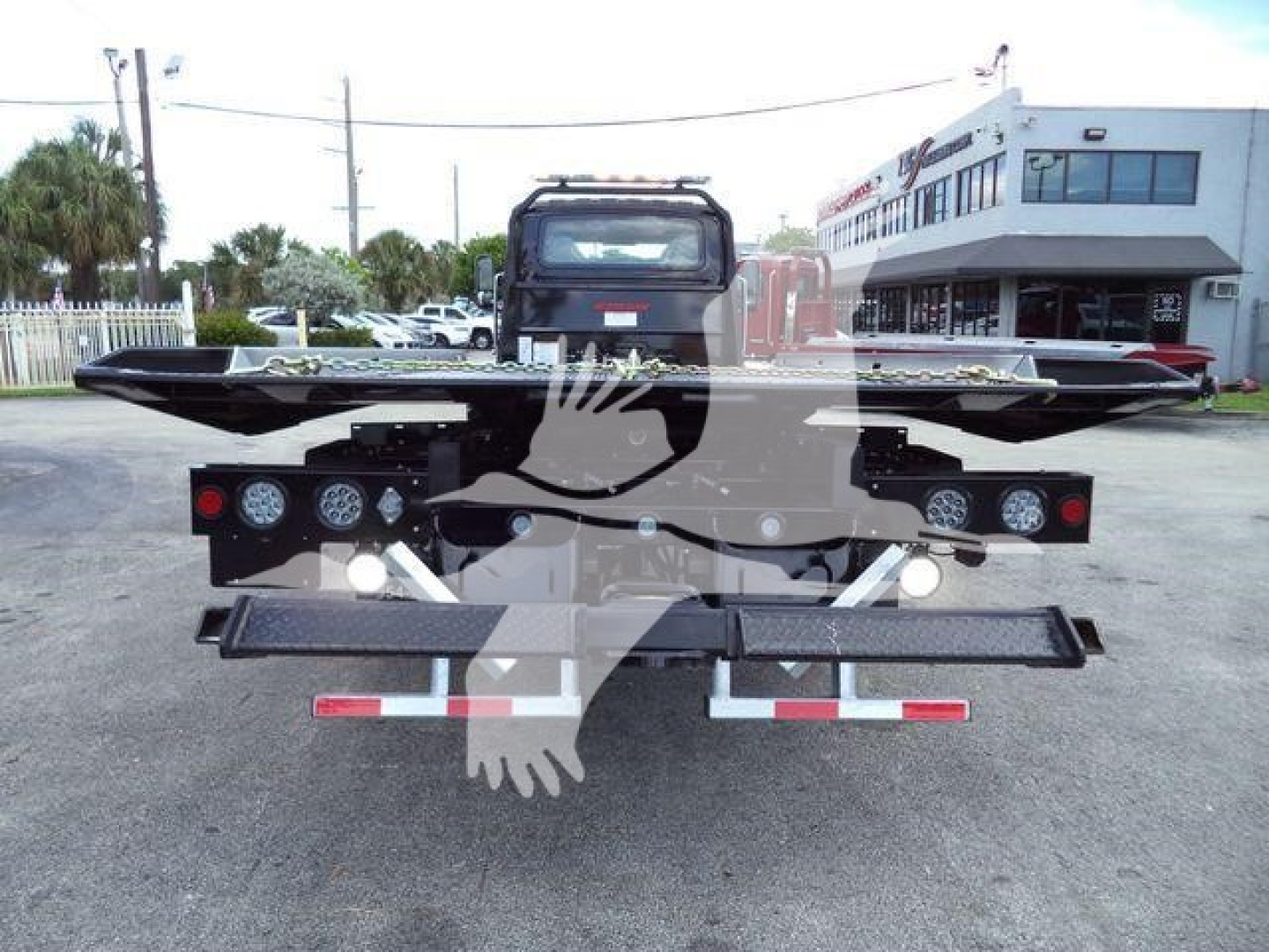 Truck bed of a 2026 International MV rollback truck showing rear lights and bumper with metal platform.