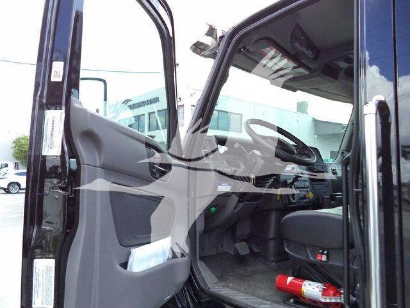 Cab interior of a 2026 International MV truck showing open driver door and dashboard with steering wheel and seat.