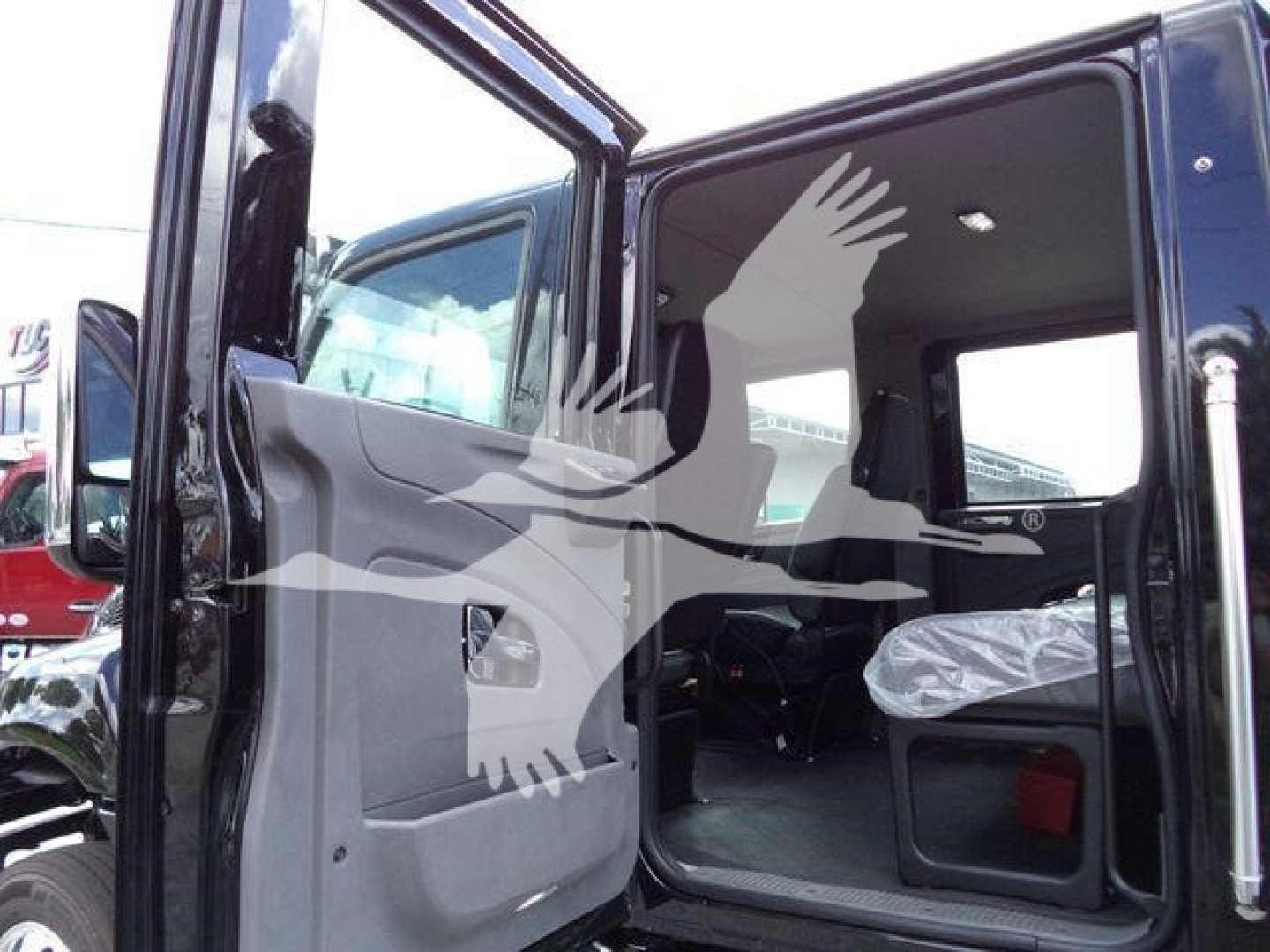 Truck cab interior view of a 2026 International MV Rollback showing open door and seating area.
