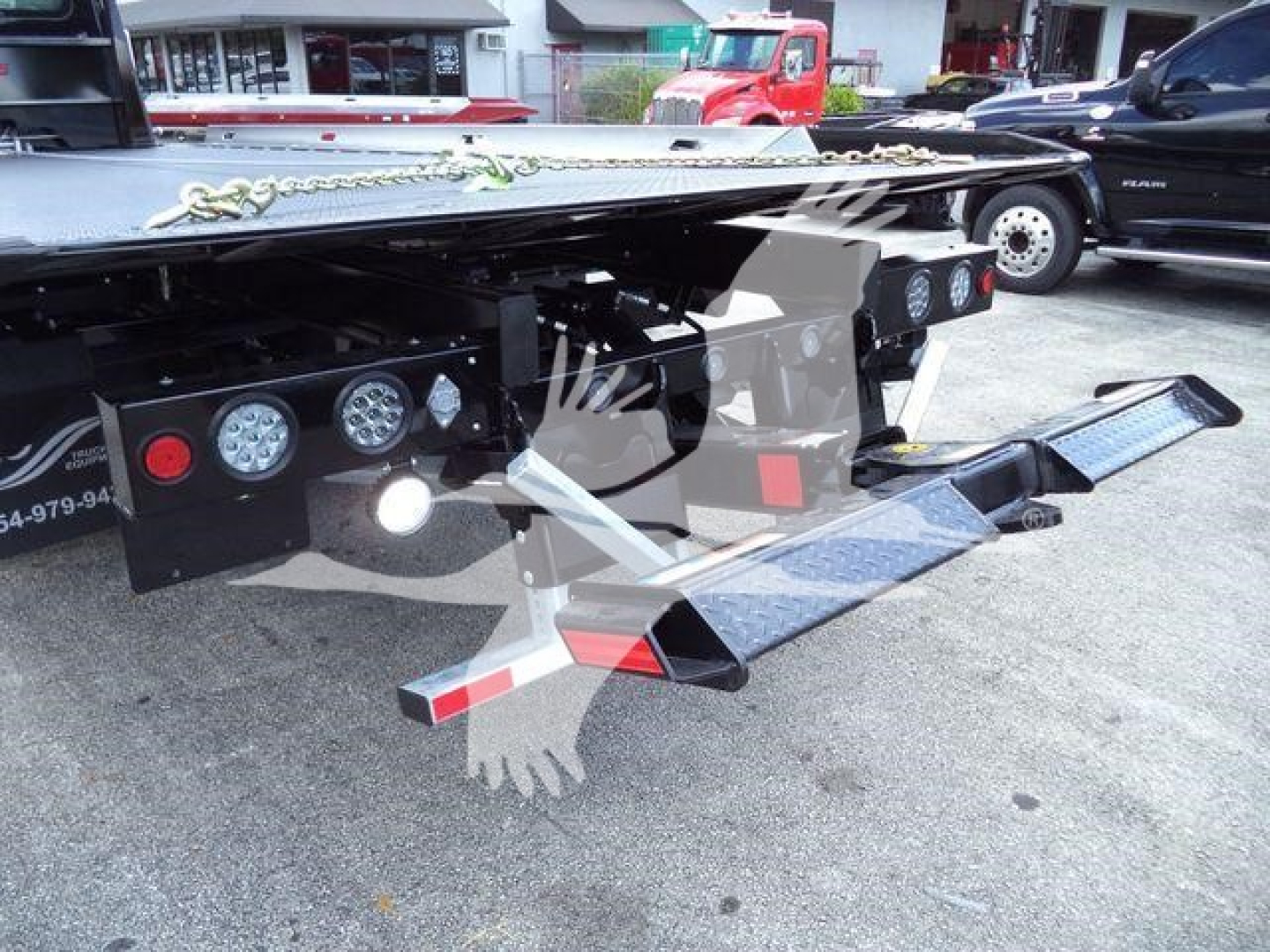 Truck rolling chassis and rear equipment showing control gauges and steps on a rollback tow truck bed.