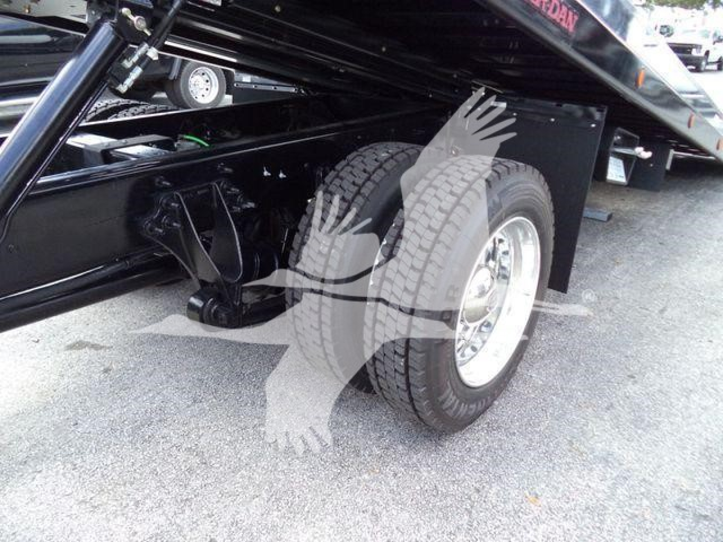 Truck rear wheel and hydraulic rollback mechanism showing dual tires and chassis, part of a new 2026 International MV rollback truck.