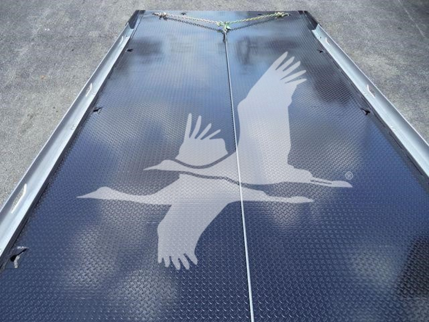 Truck bed with diamond plate surface and an eagle graphic on the tailgate.