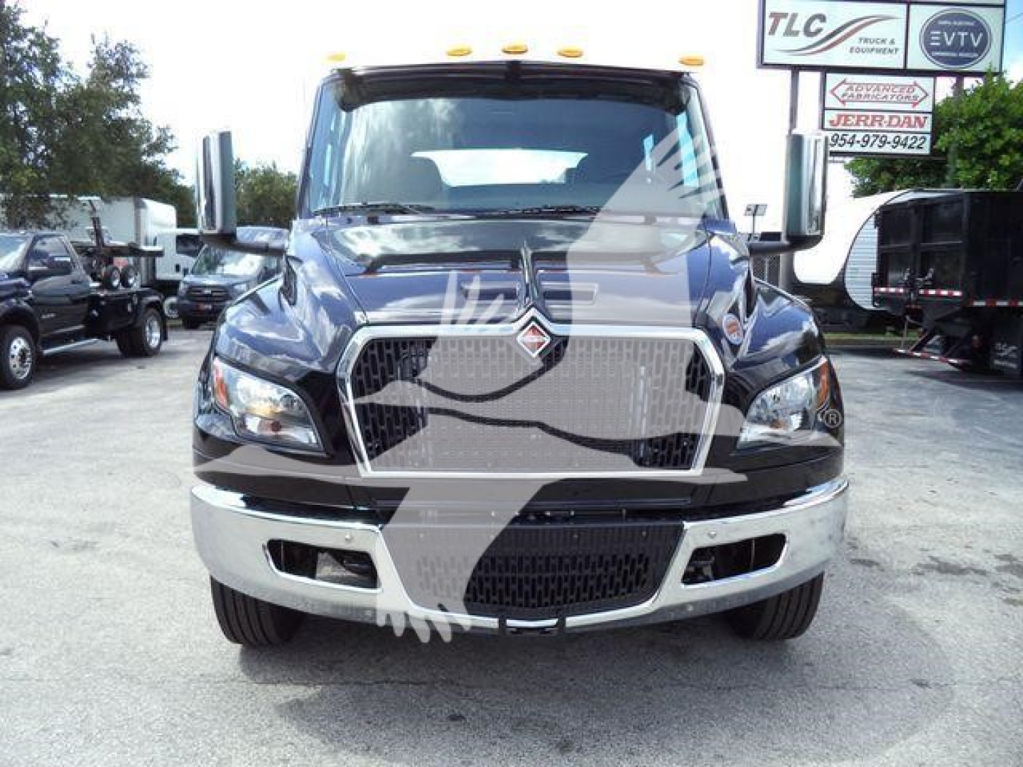 Truck front view showing grille, headlights, and bumper of a blue 2026 International MV Rollback truck.