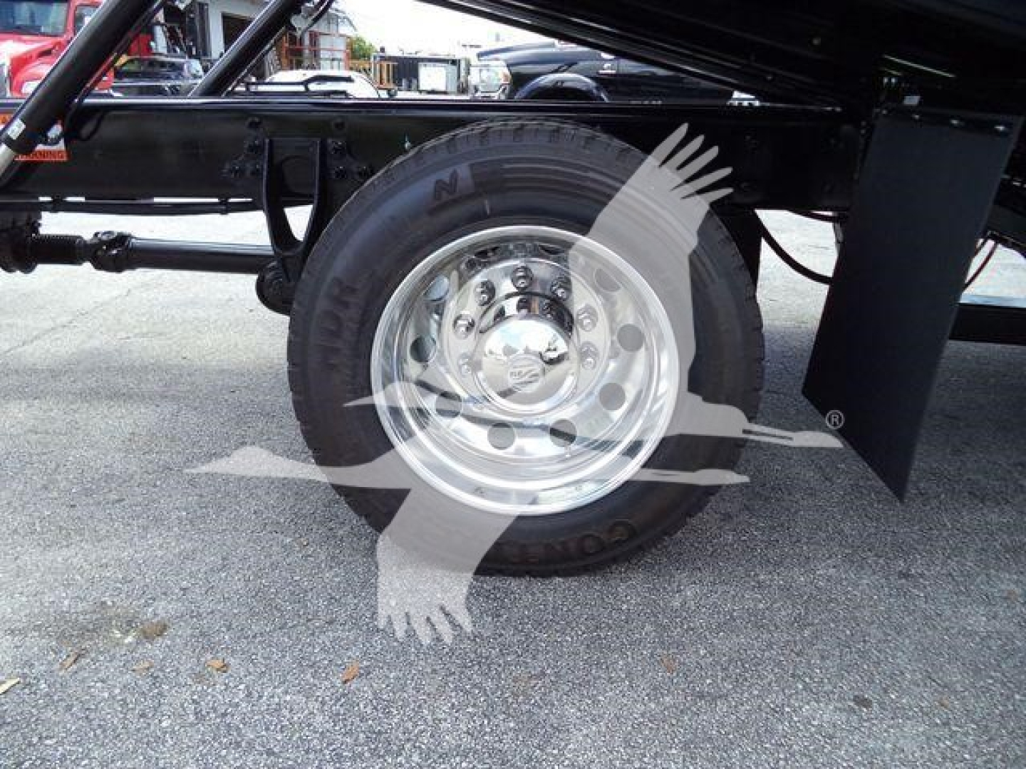 Truck wheel and chassis underside of a 2026 International MV rollback truck showing steel rim and tire profile.