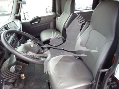 Cab interior of a 2026 International MV truck showing driver seat and passenger seat with steering wheel and dashboard