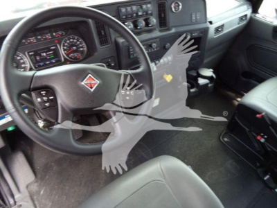 Interior of a 2026 International MV truck cab showing steering wheel with logo, dashboard, and front seats.