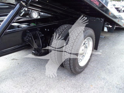 Truck rear wheel and hydraulic rollback mechanism showing dual tires and chassis, part of a new 2026 International MV rollback truck.