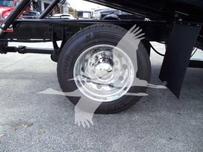 Truck wheel and chassis underside of a 2026 International MV rollback truck showing steel rim and tire profile.