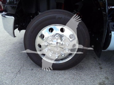 Truck wheel and chrome hub showing polished aluminum wheel with lug nuts on International MV truck, partial fender and tire visible.