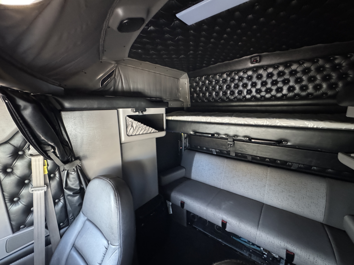 Kenworth W900L sleeper cab interior showing upholstered bunks and storage compartments.