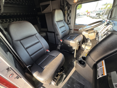 Kenworth W900L truck cab interior showing front seats and dashboard with steering wheel and center console.