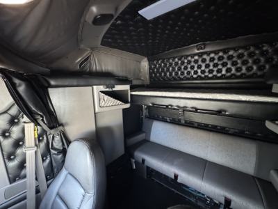 Kenworth W900L sleeper cab interior showing upholstered bunks and storage compartments.
