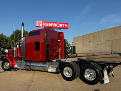 Kenworth W900L semi-truck in red with sleeper cab, dual rear axles, chrome fuel tanks, and a Kenworth sign on top.