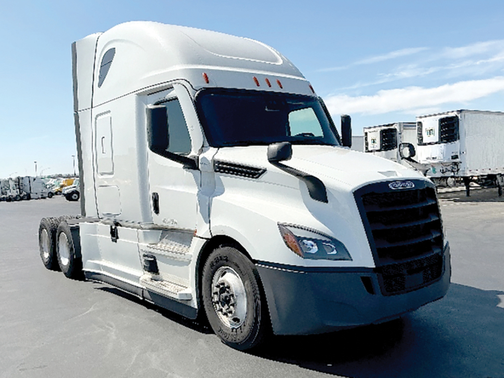 Truck cab showing 2021 Freightliner Cascadia126, white sleeper with black grille, side mirrors, bumper and 3-axle tractor; visible VIN tag and stock number not legible.