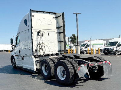 Freightliner Cascadia tractor rear chassis and fifth-wheel area showing dual rear axles and trailer connectors.