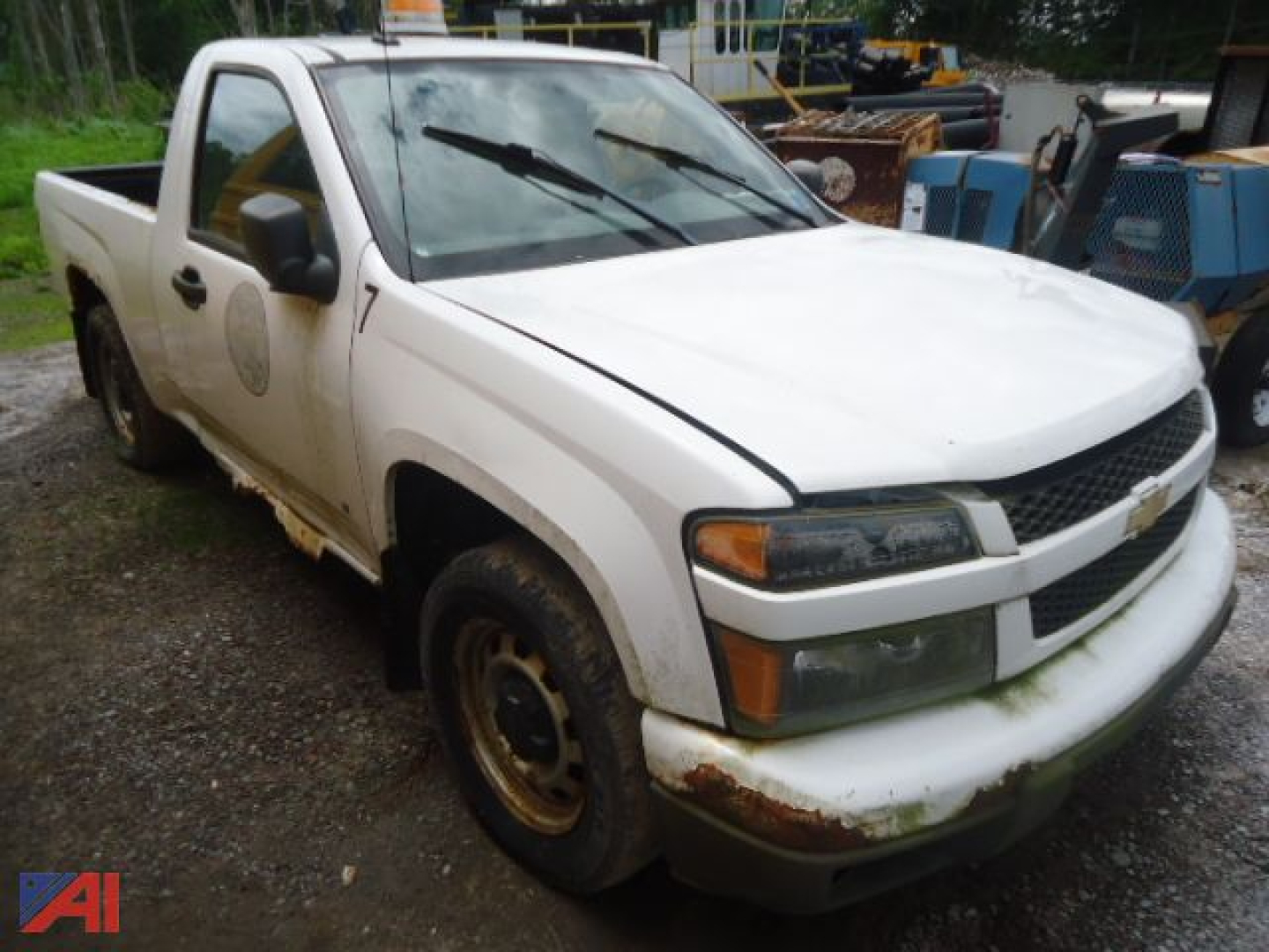 White 2009 Chevrolet Colorado pickup truck side view showing front grille, headlights, and rust on bumper and wheel wells.