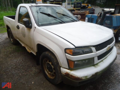 White 2009 Chevrolet Colorado pickup truck side view showing front grille, headlights, and rust on bumper and wheel wells.