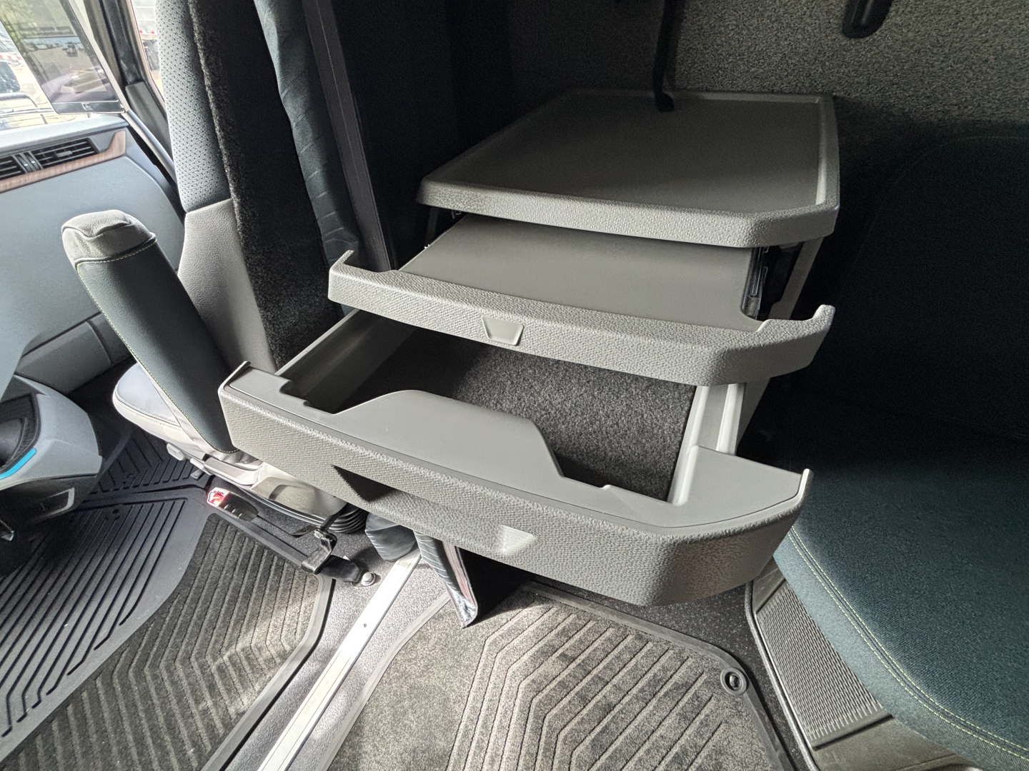 Volvo VNL64T860 cabin interior showing open center console storage drawers with multiple pull-out trays.