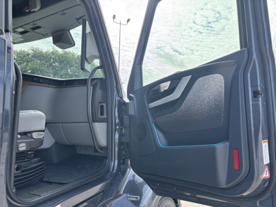 Volvo VNL64T860 truck cabin interior seen from open door, steering wheel visible, dashboard and seat area.