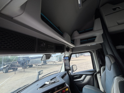 Volvo VNL64T860 truck cabin interior view with dashboard and overhead storage shelves.