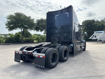 Volvo VNL64T860 tractor rear view showing fifth wheel, dual rear axles, and rear mud flaps with Volvo branding.