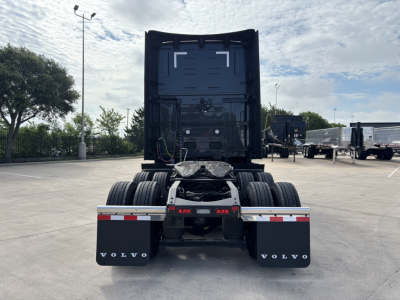 Rear view of a Volvo VNL64T860 truck chassis and fifth wheel, with dual rear axles, mud flaps labeled VOLVO, and trailer connection area visible.