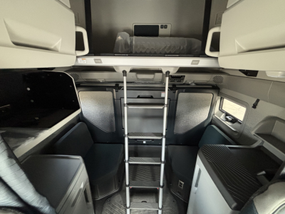Volvo VNL64T860 sleeper cab interior showing side steps ladder to upper bunk and storage compartments.